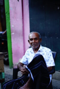 スラム街で笑顔で写真撮影に応じる現地の男性