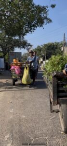 スラム街でリヤカーを引き野菜を売る男性