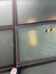 建物の吹き抜け天井にあるガラスが大きく割れており、危険な状態のまま放置されている様子